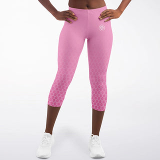 Woman wearing green Synergetic Heroes high-waisted capri leggings with a subtle logo, standing against a white background. These stylish, comfortable leggings are perfect for workouts, yoga, and active lifestyles. Shop Synergetic Heroes apparel!