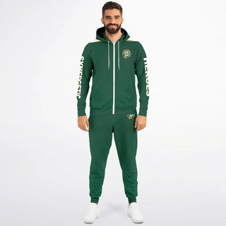 Smiling man in a green Synergetic Heroes tracksuit with a zip-up hoodie, standing against a white background. This stylish, comfortable athleisure set is perfect for casual wear, workouts, and active lifestyles. Shop Synergetic Heroes!