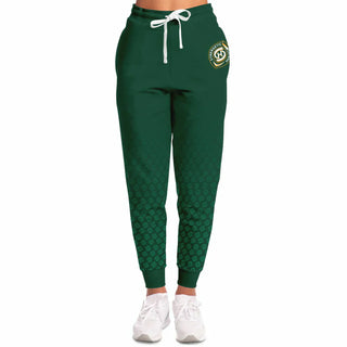 Woman wearing green Synergetic Heroes joggers with a drawstring waist and cuffed ankles, standing against a white background. These stylish, comfortable joggers are perfect for workouts, casual wear, and active lifestyles. Shop Synergetic Heroes apparel!