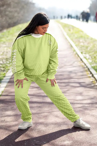 Plus-size woman stretching outdoors in a lime-green Synergetic Heroes athleisure tracksuit. This stylish, comfortable activewear set is perfect for workouts, casual wear, and active lifestyles. Shop premium plus-size athletic apparel at Synergetic Heroes.